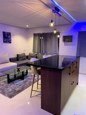 a kitchen with a counter and a living room at Duplex Luxury Appartement in Marrakech