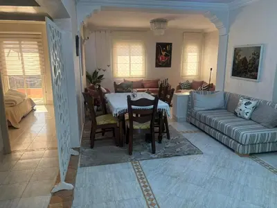 a living room with a table and a couch at Bel appartement au relaxer in Marrakech