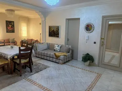 a living room with a couch and a table at Bel appartement au relaxer in Marrakech