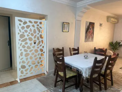 a dining room with a table and chairs at Bel appartement au relaxer in Marrakech