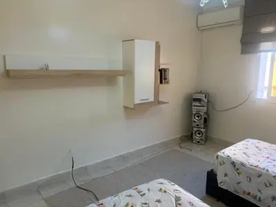 a room with two beds and a cabinet on the wall at Bel appartement au relaxer in Marrakech