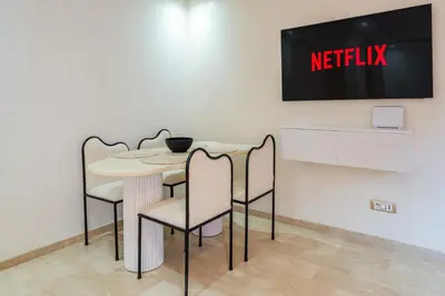 a table and chairs with anetflix sign on a wall at Downtown Gueliz Modern 1BR AC, Fast WIFI , Parking in Marrakech
