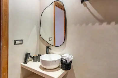 a bathroom with a sink and a mirror at Downtown Gueliz Modern 1BR AC, Fast WIFI , Parking in Marrakech