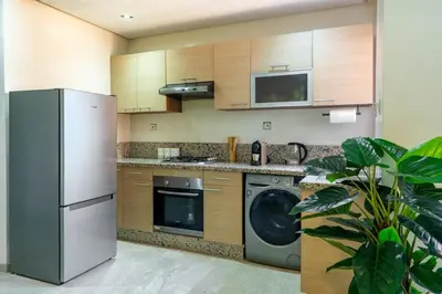 a kitchen with a refrigerator and a dishwasher at Downtown Gueliz Modern 1BR AC, Fast WIFI , Parking in Marrakech