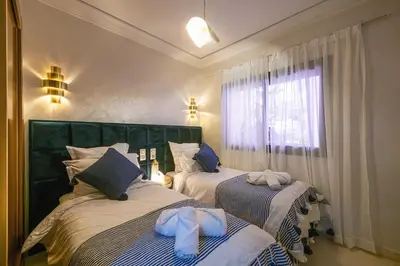 a bedroom with two beds with towels on them at Appartement Bien équipé au Centre ville Garage Privé et Climatiseur Fibre 5G in Marrakech