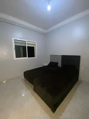 a bedroom with a black bed in a room at Appartement bros in Marrakech