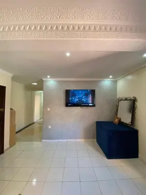 a living room with a tv on a wall at Appartement bros in Marrakech