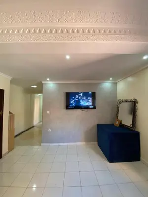 a living room with a tv on a wall at Appartement bros in Marrakech