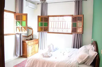 a bedroom with a bed and two windows at Maison Marrakech in Touggana