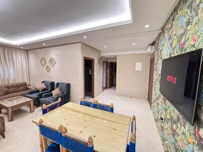 a living room with a table and a flat screen tv at The Cristal House in Marrakech