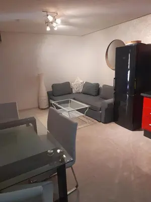 a living room with a couch and a tv at Opéra A Studio Apartment in Marrakech