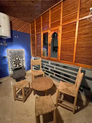a room with wooden furniture and a table and chairs at Opéra A Studio Apartment in Marrakech