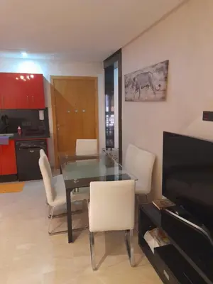 a dining room with a glass table and white chairs at Opéra A Studio Apartment in Marrakech