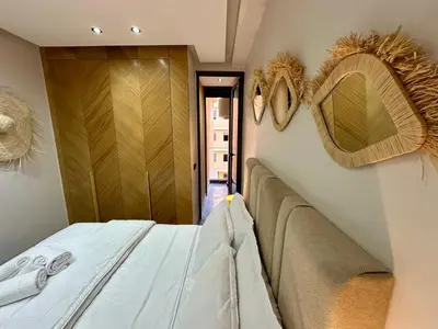 a bedroom with a bed and two mirrors on the wall at Petit paradis près du centre in Marrakech