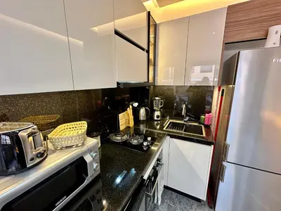a kitchen with white cabinets and a stainless steel refrigerator at Petit paradis près du centre in Marrakech