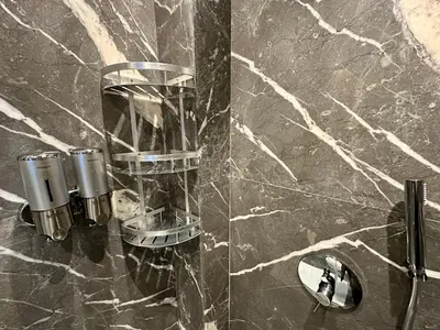 a bathroom with a black marble wall with a mirror at Petit paradis près du centre in Marrakech