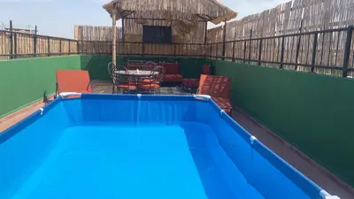 a blue swimming pool with chairs and a table at Appartement privatisé Gazelles MsHolidays Marrakech in Marrakech