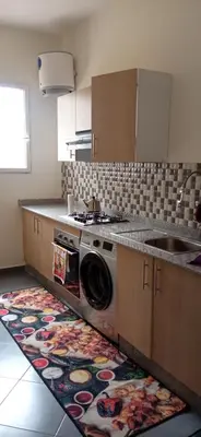 a kitchen with a washing machine on a rug at appartement meublé accoté de l aéroport Marrakech in Marrakech