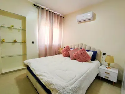a bedroom with a bed with pink pillows on it at Chic & Comfort Apartment in Marrakech