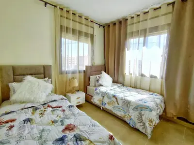 a bedroom with two beds and a window at Chic & Comfort Apartment in Marrakech