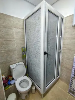 a bathroom with a toilet and a glass shower at Chic & Comfort Apartment in Marrakech