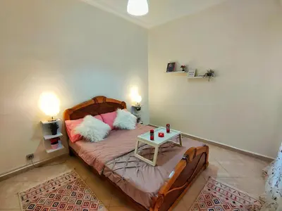 a bedroom with a bed with a table on it at Stylish & Bright Apartment in Marrakech