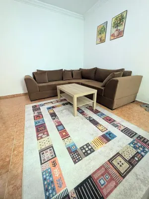 a living room with a couch and a table on a rug at Cozy studio in a good location in Marrakech