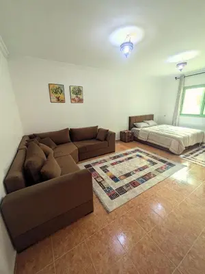 a living room with a couch and a bed at Cozy studio in a good location in Marrakech