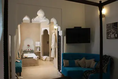 a living room with a blue couch and a bedroom at Riad La Villa Marrakech in Marrakech