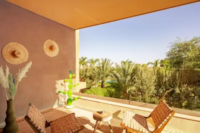 a room with a balcony with a table and chairs at Luxurious Apartment in Marrakech in Dar Caïd Layadi