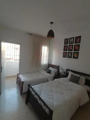 a bedroom with two beds and a window at Appartement cosy in Marrakech