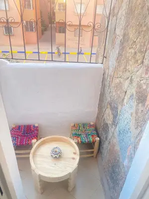 a room with a bench and a table and a window at Appartement cosy in Marrakech