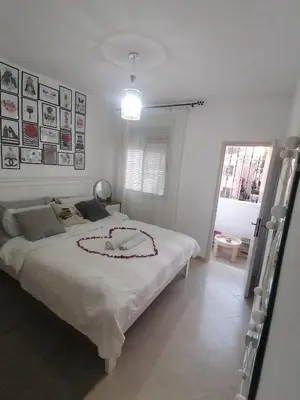a bedroom with a large white bed with a necklace on it at Appartement cosy in Marrakech