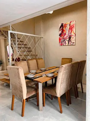 a dining room with a wooden table and chairs at Majestic Duplex - Luxe et Confort au Cœur de Marrakech in Marrakech