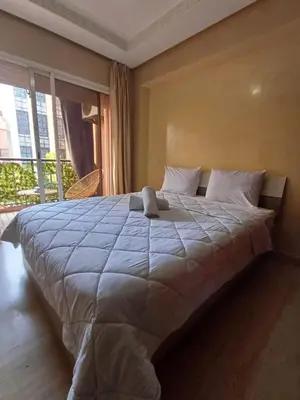 a large bed in a room with a large window at Appartement familial résidence Hamza 2 chambres in Marrakech