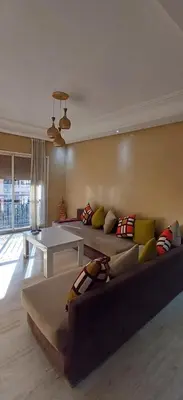a living room with a couch and a table at Appartement familial résidence Hamza 2 chambres in Marrakech