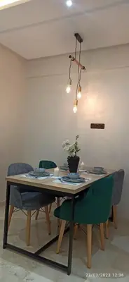 a dining room table with chairs and a potted plant on it at luxurious and stylish apartment in Marrakech