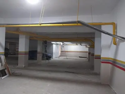 an empty parking garage with a yellow pipe on the wall at family apartment 18 in Marrakech