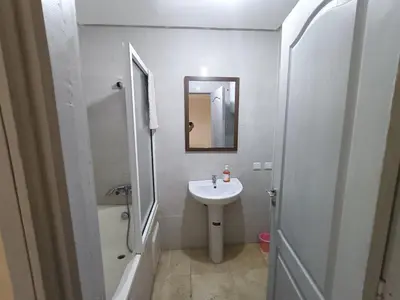 a white bathroom with a sink and a mirror at family apartment 31 in Marrakech