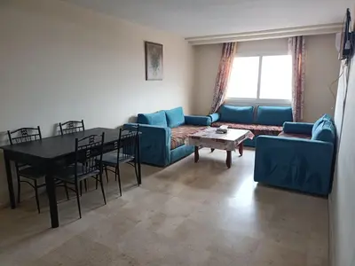 a living room with a blue couch and a table at family apartment 31 in Marrakech