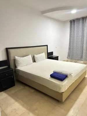 a bedroom with a large bed with a blue blanket at family apartment 32 in Marrakech