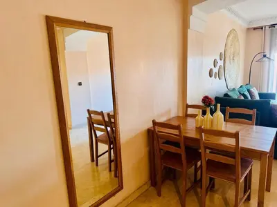 a dining room with a table and a mirror at Résidence Miramas 2 Cosy Appartment 2 in Marrakech