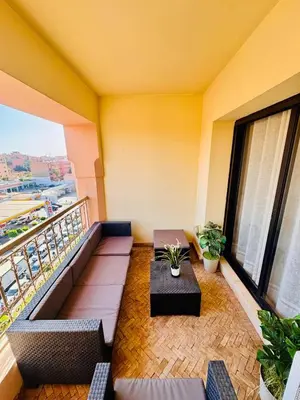 a balcony with couches and a table on a building at Résidence Miramas 2 Cosy Appartment 2 in Marrakech