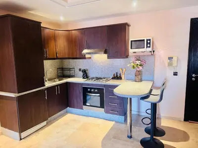a kitchen with wooden cabinets and a counter top at Résidence Miramas 2 Cosy Appartment 2 in Marrakech
