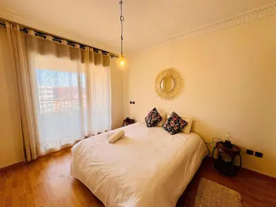 a bedroom with a large white bed with a window at Résidence Miramas 2 Cosy Appartment 2 in Marrakech