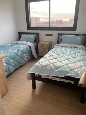 a bedroom with two twin beds and a window at Appartement 2 chombr salon a marrakech in Marrakech