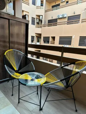 two chairs and a glass table on a balcony at Appartement a gueliz Marrakech in Marrakech