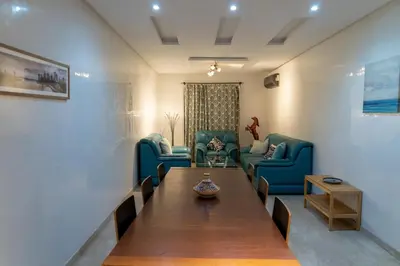 a living room with a table and blue chairs at Two Bedroom Luxury Appt with air conditioning parking and pool in Marrakech