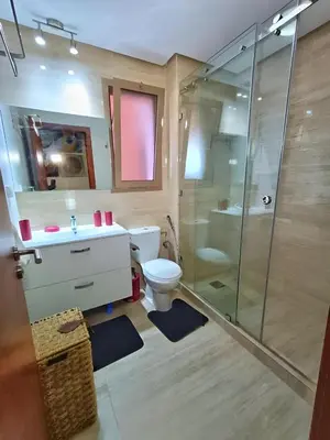 a bathroom with a shower and a toilet and a sink at Luxueux Appartement Prestigia Agate in Marrakech