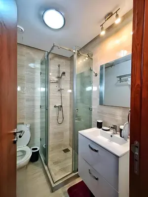 a bathroom with a shower and a sink and a toilet at Luxueux Appartement Prestigia Agate in Marrakech